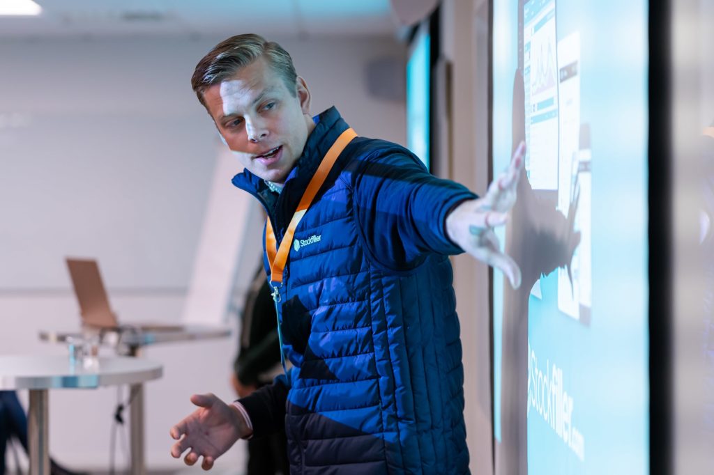 Man speaking and standing in front of screen